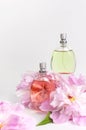 Beautiful composition with perfume and flowers. Perfume bottle, pink flowers peonies green leaves on light background Flat lay Royalty Free Stock Photo