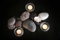 Beautiful composition with spa stones and burning candles on black background, top view Royalty Free Stock Photo
