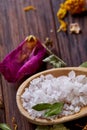 Composition of spa treatment on wooden background. Sea salt and flowers background, close up, top view, selective focus. Royalty Free Stock Photo