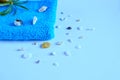Beautiful composition of a towel with stones, shells and spa on a blue background. Holiday towels