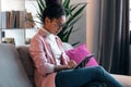 Beautiful concentrated young entrepreneur woman using her digital tablet while sitting on couch in the office Royalty Free Stock Photo