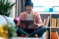 Beautiful concentrated young entrepreneur woman using her digital tablet while sitting on couch in the office Royalty Free Stock Photo