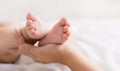 Little baby feet in mother hands closeup Royalty Free Stock Photo