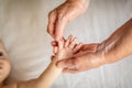 Beautiful conceptual image of new life. hands of an old woman and hand newborn baby