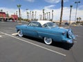 Light blue and white 1950s Ford Crestline in parking lot - rear driver side view