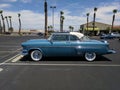 Light blue and white 1950s Ford Crestline in parking lot - driver side view