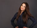 Beautiful confident calm thinking smiling business woman satnding in power pose in blue shirt on grey background with empty copy