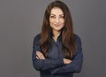 Beautiful confident happy smiling business woman with folded arms in blue shirt on grey background with empty copy space for text Royalty Free Stock Photo