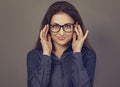 Beautiful confident thinking smiling business brunette woman holding two hands the glasses on the face in blue shirt on grey Royalty Free Stock Photo