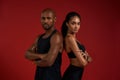 Beautiful and confident. Young african fitness couple in sportswear looking at camera while standing against red Royalty Free Stock Photo