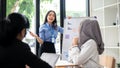 A confident Asian businesswoman is presenting data on the board to her team in the meeting Royalty Free Stock Photo