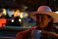 A beautiful contented woman enjoys at the cafe in the evening
