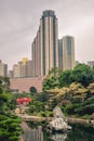 Beautiful contrast between the green trees and blooming flowers and high rise buildings in the Nan Lian Garden in Hong