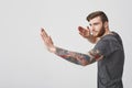Beautiful cool european bearded man with tattoo and good-looking hairstyle looking aside having concentrated expression Royalty Free Stock Photo