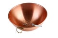 A beautiful copper mixing bowl with a whisk in it on white with nice reflections