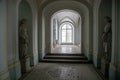 A beautiful corridor with statues and a window Royalty Free Stock Photo