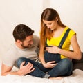 Beautiful coule - young man and pregnant woman resting on bed Royalty Free Stock Photo