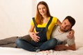 Beautiful coule - young man and pregnant woman resting on bed Royalty Free Stock Photo