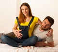 Beautiful coule - young man and pregnant woman resting on bed Royalty Free Stock Photo