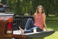 Beautiful country girl on back of pick-up truck Royalty Free Stock Photo