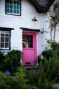 A beautiful countryside cottage with pink door Royalty Free Stock Photo