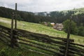 Old vintage wooden fence in foreground, village, meadows Royalty Free Stock Photo