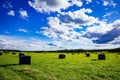 Beautiful countryside landscape. Round straw bales in black plastic in green field Royalty Free Stock Photo