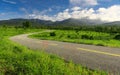 Beautiful countryside road in green field under blue sky Royalty Free Stock Photo