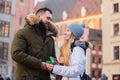 couple, boyfriend give a present gift box to a girlfriend on Christmas fair in Wroclaw, Poland