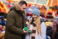 couple, boyfriend give a present gift box to a girlfriend on Christmas fair in Wroclaw, Poland