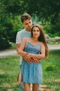 Couple in bright clothes walks in a summer park in the city. Walk in the fresh air. Date of two lovers. The period of co