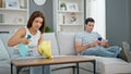 Beautiful couple cleaning while girlfriend using smartphone at home Royalty Free Stock Photo