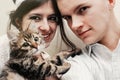 Beautiful couple with cute funny kitten with bow tie on white ba Royalty Free Stock Photo