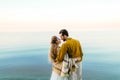 A beautiful couple is embracing on the sea background. Moment before the kiss. Romantic date on the beach. View from the Royalty Free Stock Photo