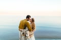 A beautiful couple is embracing on the sea background. Moment before the kiss. Romantic date on the beach. View from the Royalty Free Stock Photo