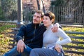 Young couple is sitting on a bench in the park in Rome.