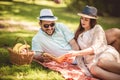 Couple enjoying picnic time outdoor reading book