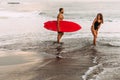 Beautiful couple have fun at the sea. Couple in love on the beach with a surfboard at sunset. Royalty Free Stock Photo