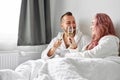 Beautiful couple have romantic time on bed drinking champagne Royalty Free Stock Photo