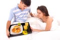 Beautiful couple having breakfast lying in the bed Royalty Free Stock Photo