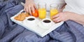 Beautiful couple having breakfast lying in bed at home. Handsome man and attractive woman are enjoying spending time Royalty Free Stock Photo