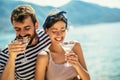 Couple having fun on the beach, drinking cocktails and smiling Royalty Free Stock Photo