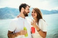 Couple having fun on the beach, drinking cocktails and smiling Royalty Free Stock Photo