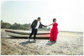 Beautiful couple holding hands by rowboat at beach Royalty Free Stock Photo
