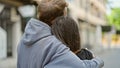 Beautiful couple hugging each other standing backwards at street