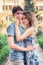 Beautiful couple hugging and looking at the camera. Green park and old building on the background. Royalty Free Stock Photo