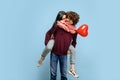 Beautiful couple in love on blue studio background. Valentine's Day, love and emotions concept Royalty Free Stock Photo