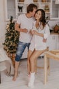 Beautiful couple in love celebreting Christmas. Kitchen breakfast - Image