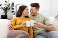Beautiful couple in love drinking tea together in living room Royalty Free Stock Photo