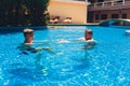 Beautiful couple in love enjoying themselves in pool at summer resort. Royalty Free Stock Photo